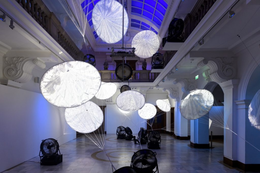 The Gallery's Atrium space, filled with floating parachutes, each one with it's own projected image of elements of the natural world