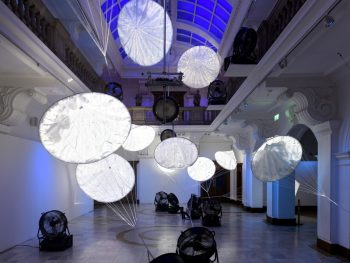 The Gallery's Atrium space, filled with floating parachutes, each one with it's own projected image of elements of the natural world